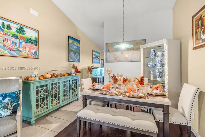 Vaulted ceiling, decorative pendant light fixture, and tile flooring