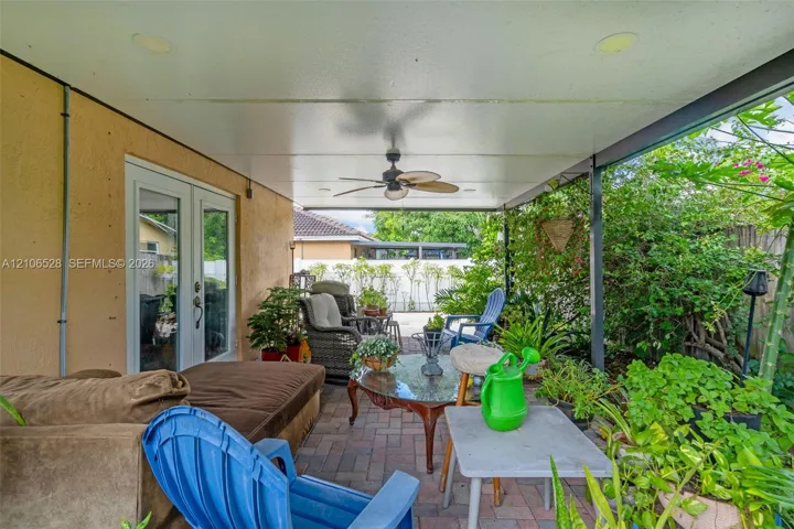 Covered patio featuring a paved brick floor, recessed ceiling lighting, a ceiling fan, and French glass entry doors