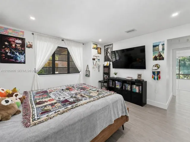 Neutral-toned wood-finish flooring, recessed lighting, and expansive window with dark-framed panes