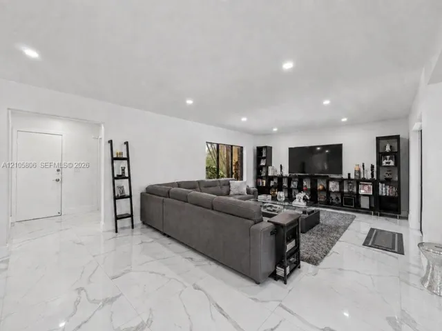Polished large-format tile flooring with vein detailing, recessed ceiling lighting, and crisp neutral wall finishes