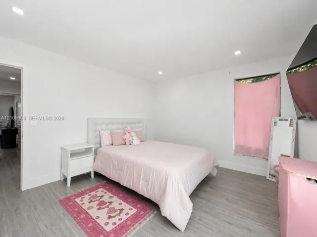 Neutral walls, wood-finish flooring, and recessed lighting