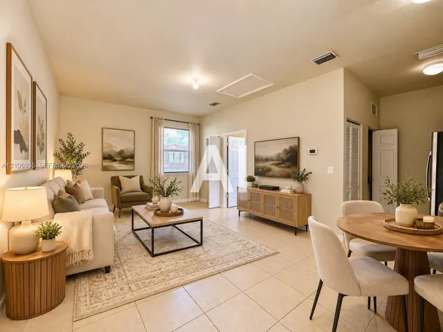 Open-concept interior featuring light-toned tile flooring, recessed lighting, and a single window with neutral drapery