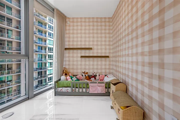 Floor-to-ceiling windows with expansive glass panels, light-toned check-patterned wall covering, dual built-in wall shelves, and polished stone-finish tile flooring