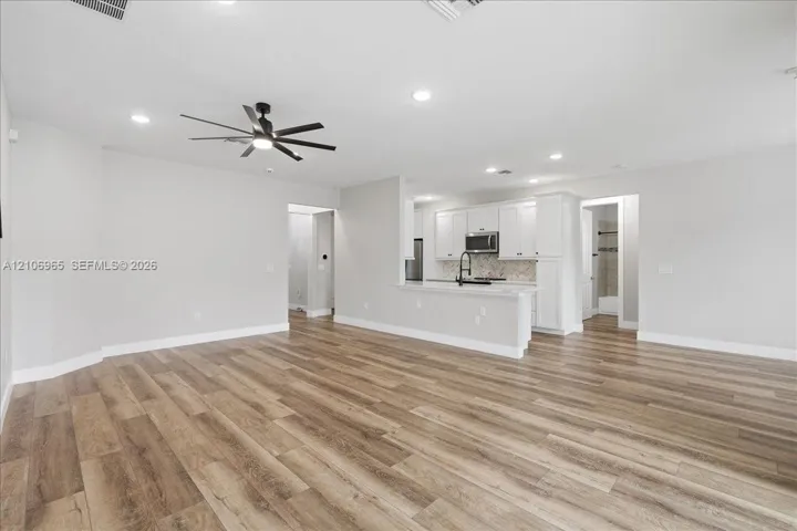 Open-concept interior featuring wood-finish flooring, recessed lighting, and a modern ceiling fan