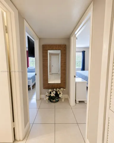Neutral-toned ceramic tile flooring, solid-core interior doors, and crisp white door casing