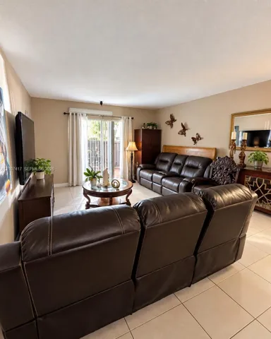 Living area featuring large format tile flooring and sliding glass doors with access to an exterior space