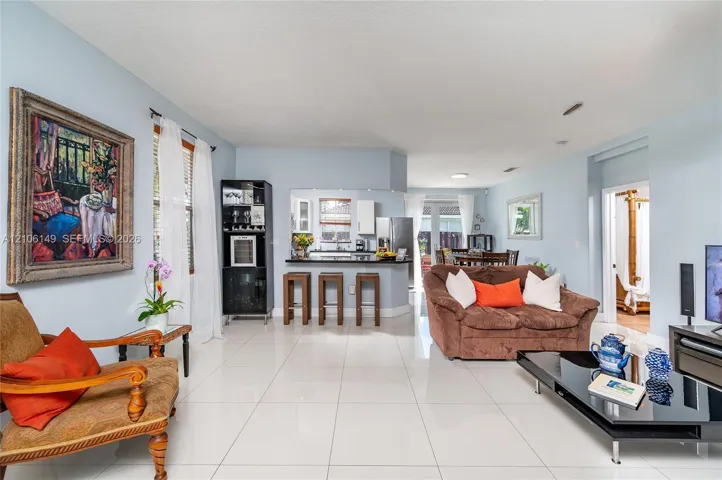 Open-concept interior featuring large-format tile flooring, a kitchen pass-through counter, and built-in cabinetry