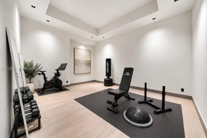 Neutral interior room featuring wood-finish flooring, recessed ceiling lighting, and a recessed tray ceiling detail