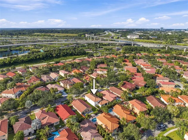 Aerial perspective of a single-story residence featuring a tile roof and a private swimming pool