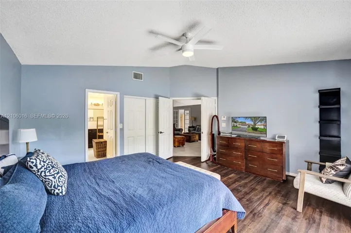 Vaulted ceiling with integrated lighting, wood-finish flooring, and double-door entry