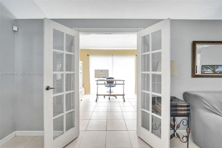 White-framed French doors with glass panes and ceramic tile flooring