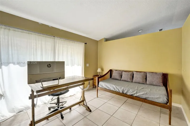 Interior space featuring tile flooring, neutral wall paint, and a sliding glass door