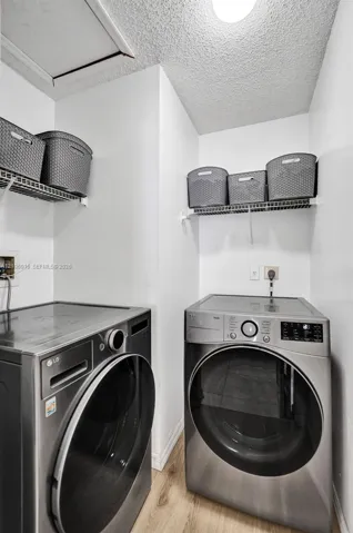 Dedicated laundry area featuring wire shelving and wood-finish flooring