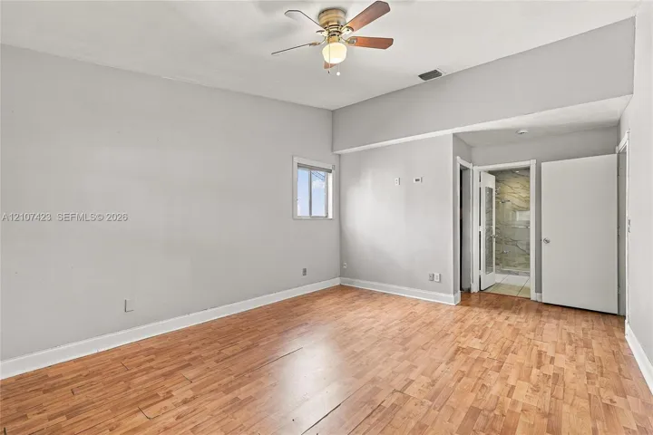 Room featuring wood-finish flooring, vaulted ceiling, and a central ceiling fan with integrated lighting