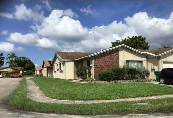 Single-story residence featuring a brick exterior accent, gabled roofline, and an attached garage