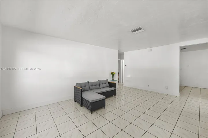 Neutral-toned interior featuring smooth white walls and ceramic tile flooring