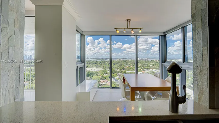 Floor-to-ceiling windows, quartz countertop, multi-light metallic fixture, stone-accented columns, and extensive cityscape scenery
