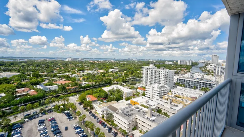 Elevated balcony with a metal railing offering expansive horizon and urban scenery