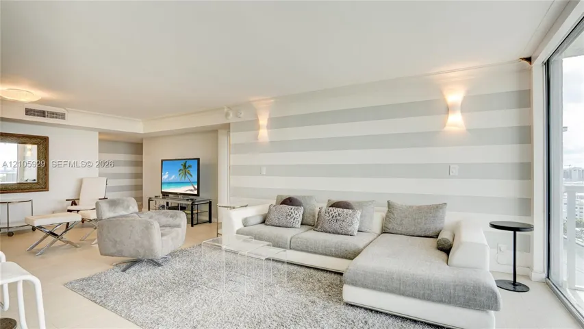 Spacious room featuring neutral-toned horizontal wall stripes, floor-to-ceiling glass sliding doors, and recessed wall-mounted lighting