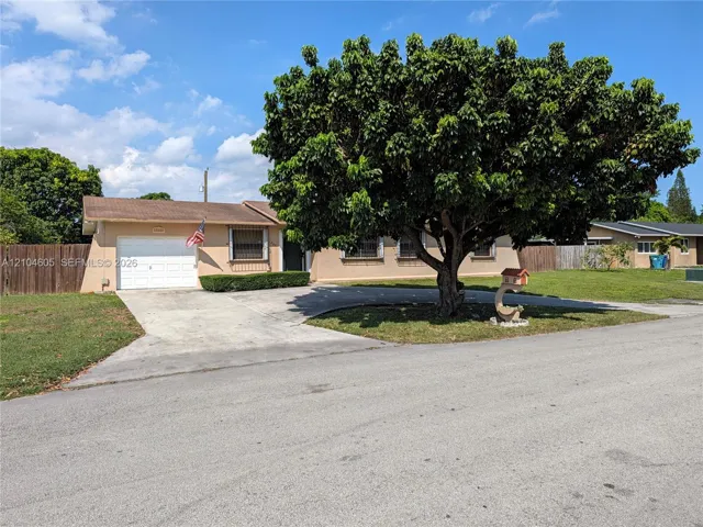Single-story residence featuring a concrete driveway, attached one-car garage, mature landscaping, and wood-toned exterior finish