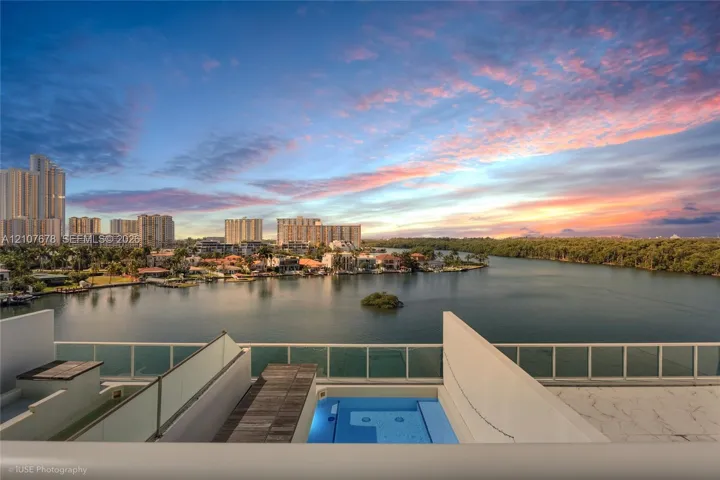 Terrace featuring a plunge pool, wood-finish decking, glass panel railing, and water scenery