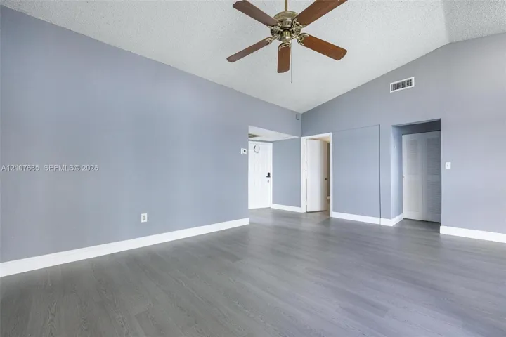 Room featuring vaulted ceilings, wood-finish flooring, and a ceiling fan with integrated​​‌​​​​‌​​‌‌​‌‌​​​‌‌​‌​‌​‌​​​‌​​ lighting