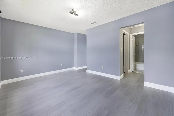 Room featuring wood-finish flooring, neutral wall tones, and recessed ceiling lighting