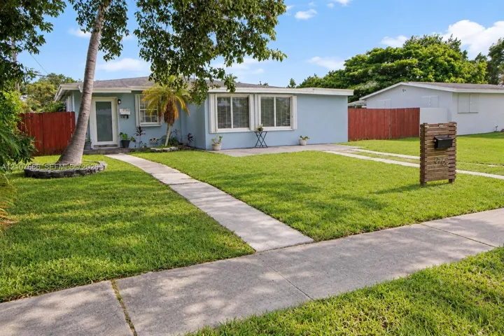 Single-story residence featuring a light-toned exterior, concrete walkway, horizontal wood-slat mailbox post, and perimeter privacy fencing