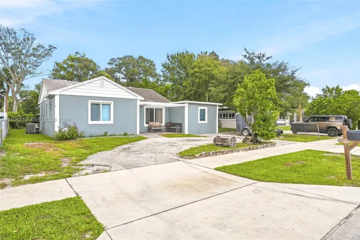 Single-story residence featuring light blue exterior siding, white trim, a covered front entryway, and a concrete driveway