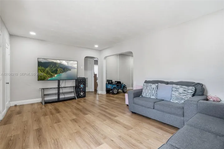 Interior space featuring wood-finish flooring, recessed lighting, and arched doorways
