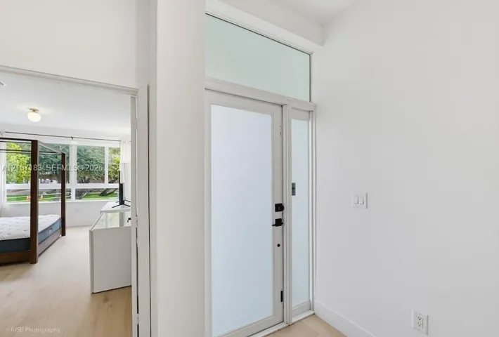 Entryway featuring a glass-panel door with frosted finish, transom window, and wood-finish flooring