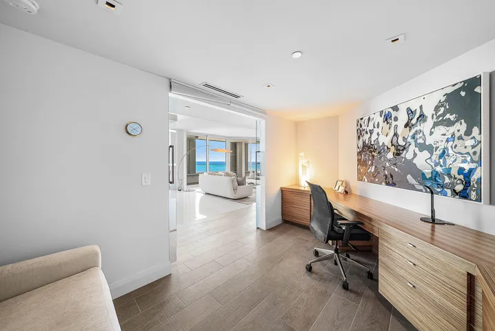 Built-in wood-finish cabinetry, recessed ceiling lighting, glass-paneled interior entry, and wood-finish flooring