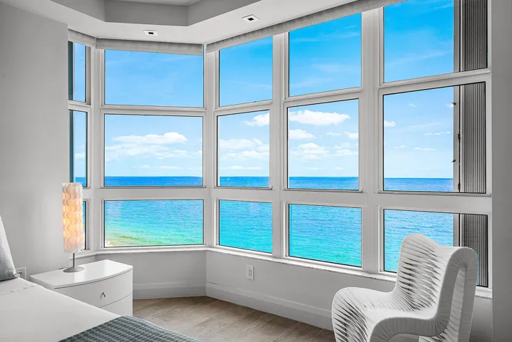 Expansive bay window featuring multi-pane glass panels, recessed ceiling lighting, and wood-finish flooring