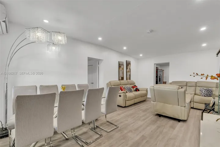 Wood-finish flooring, recessed lighting, and multi-arm crystal-style overhead lighting