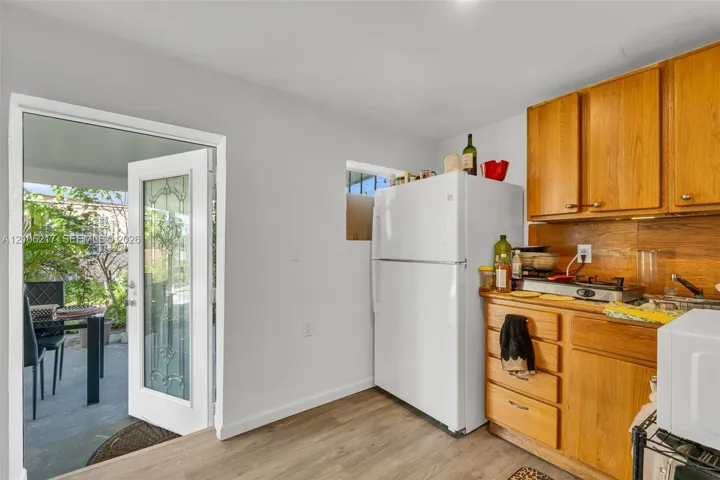 Kitchen featuring wood-finish cabinetry, wood-style flooring, and a glass-paneled entry door