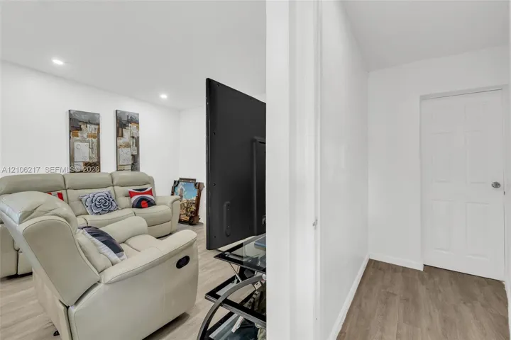 Interior space featuring recessed lighting, wood-finish flooring, and a six-panel interior door