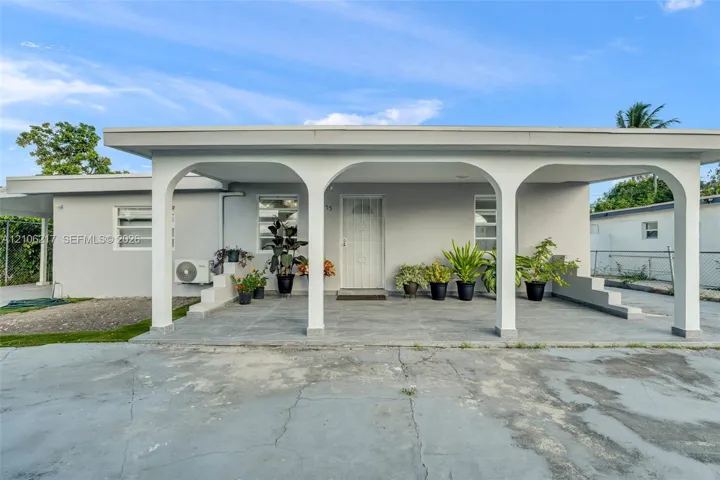 Covered arched entryway featuring stone-finish flooring and a central glass-panel entry door