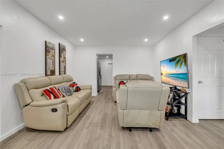 Wood-finish flooring, recessed lighting, and a six-panel interior door