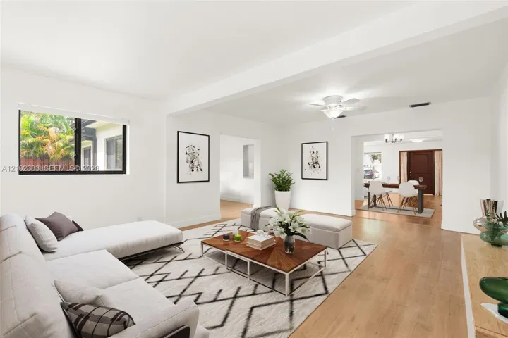 Open-concept interior featuring light wood-finish flooring, a neutral color palette, recessed ceiling lighting, and a multi-blade ceiling fan with an integrated light fixture