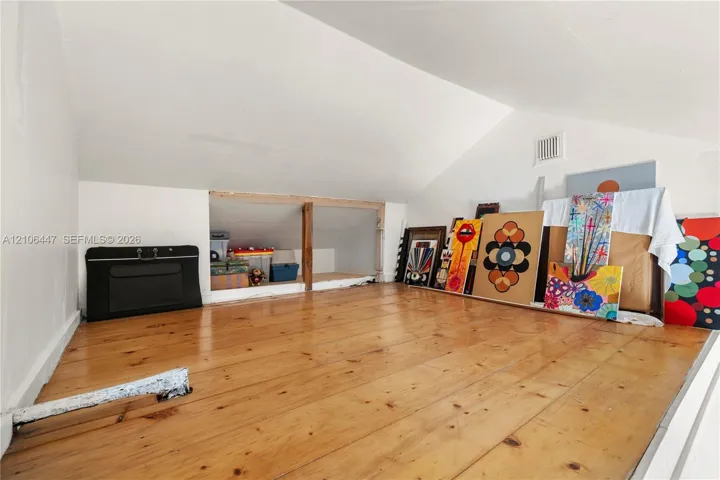 Loft area featuring sloped ceilings and wood-finish flooring