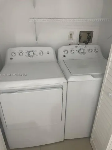 Laundry space featuring a top-load washer, a front-load dryer, and overhead wire shelving