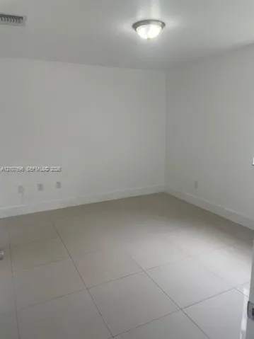 Neutral-toned interior space featuring polished large-format tile flooring, smooth wall finishes, and a dome-style flush-mount ceiling light fixture
