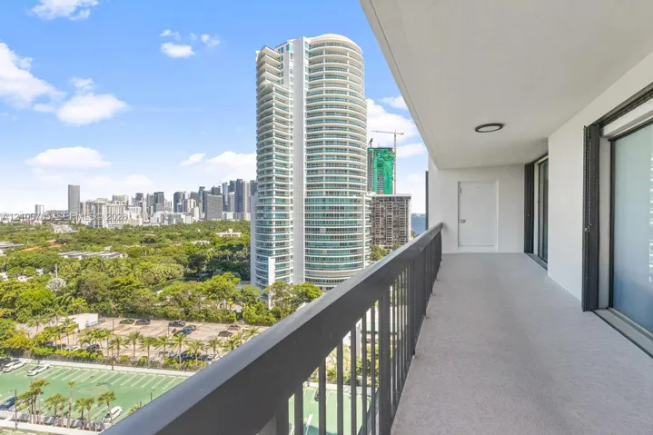 Covered private balcony featuring a neutral concrete floor, solid railing, and a flush-mount ceiling light