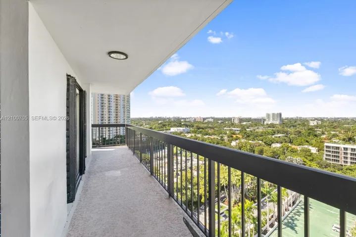 Covered balcony featuring textured flooring, recessed lighting, and a black metal railing