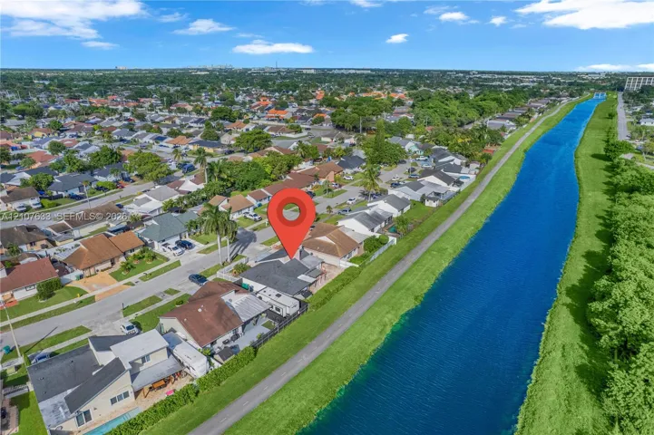 Aerial perspective featuring a single-family residence situated on a lot bordering a waterway