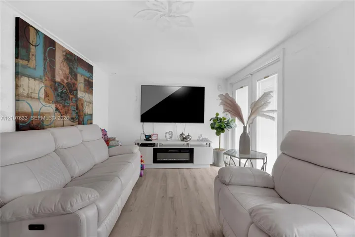 Wood-finish flooring, recessed ceiling medallion, and double-panel glass door