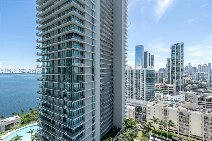 High-rise tower featuring floor-to-ceiling glass windows, expansive private wraparound balconies, and a reinforced concrete facade