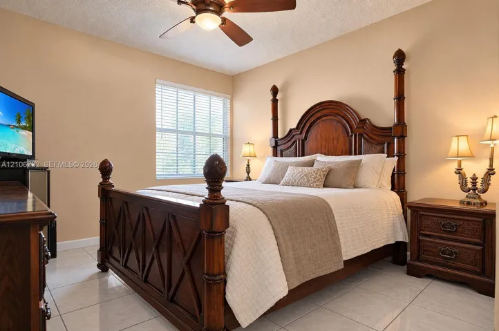Neutral-toned walls, tile flooring, and a ceiling fan with integrated lighting