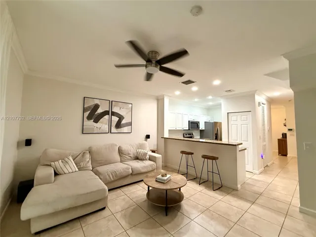 Open floor plan featuring tile flooring, ceiling fan, recessed lighting, and a kitchen breakfast bar