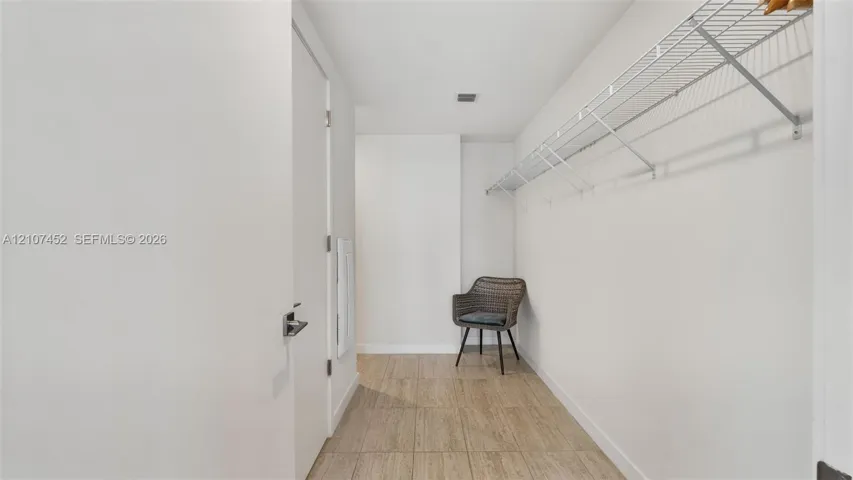 Walk-in closet featuring wood-finish flooring and wall-mounted wire shelving